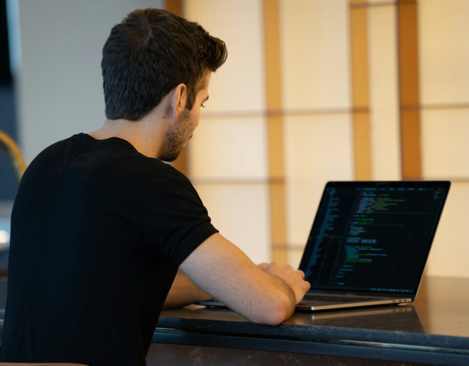 man in black t-shirt using laptop computer
